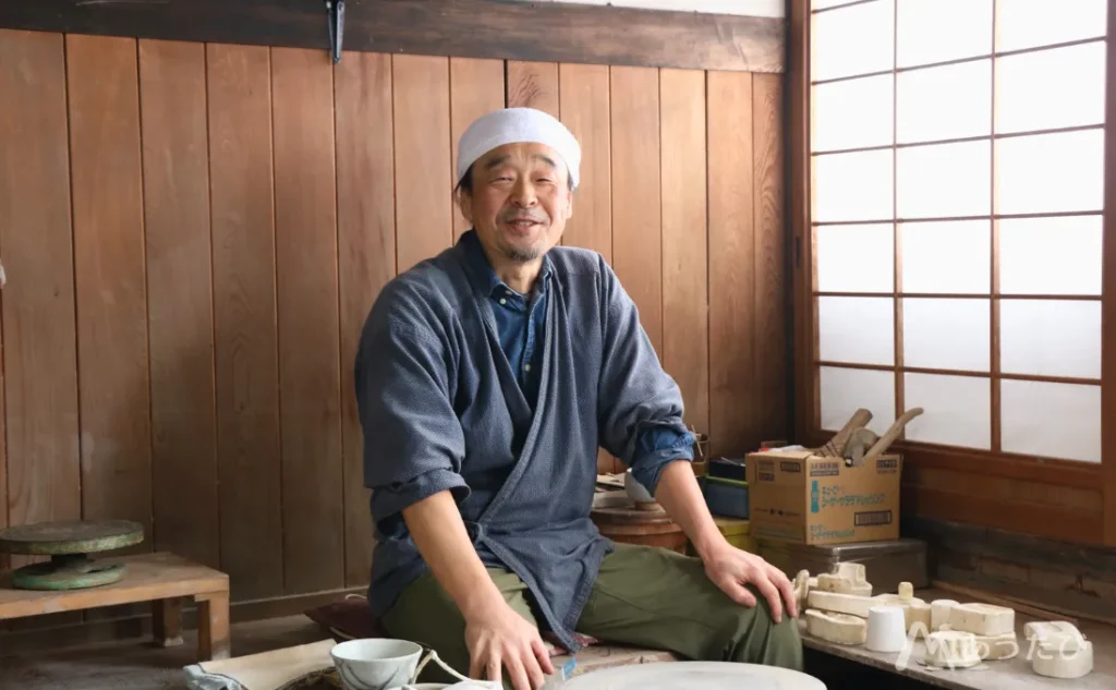 Kaneda smiling inside his pottery workshop
