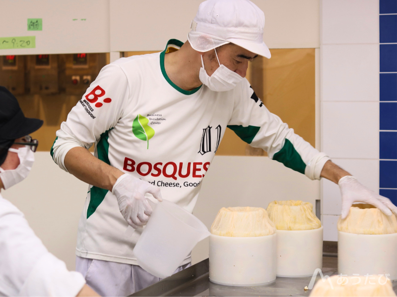 Kensuke making cheese in the workshop