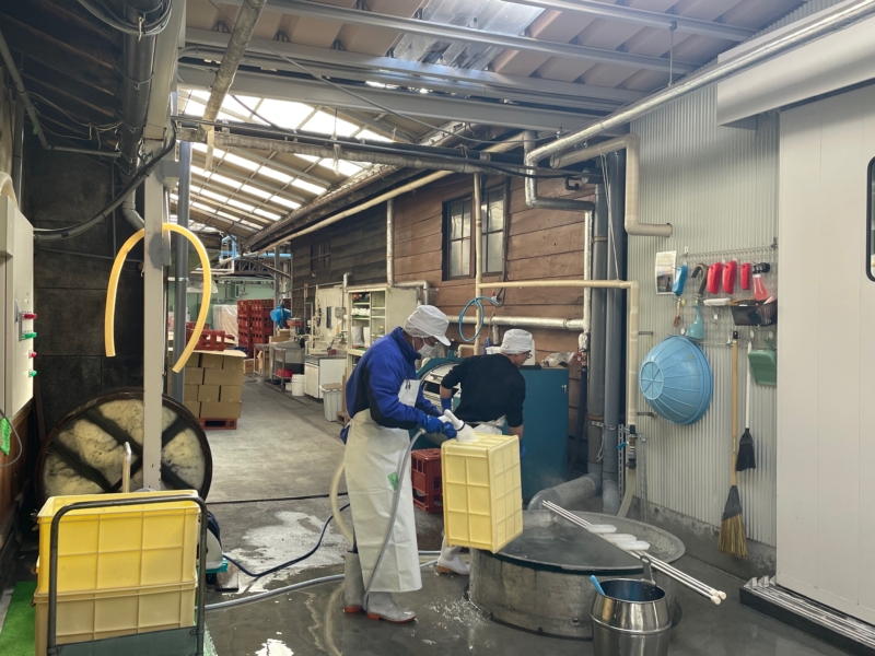 Active sake brewery interior with workers
