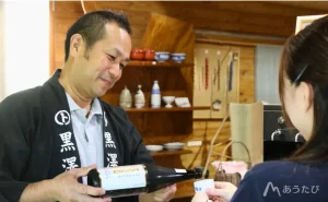 Kurosawa pouring sake into a glass