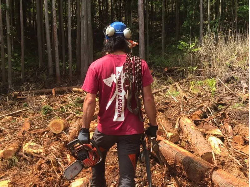 Japanese lumberjack holding a chainsaw in the forest