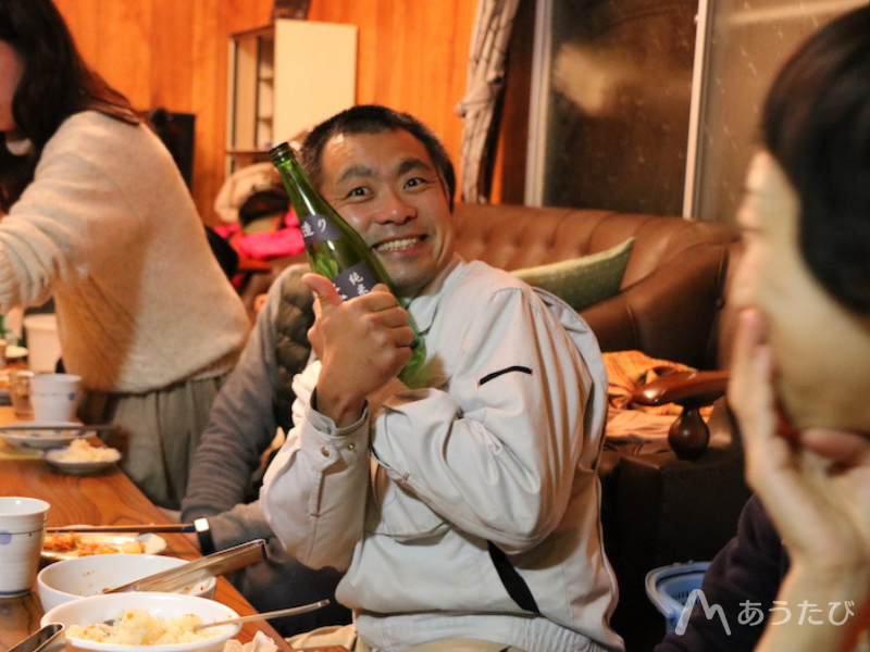 Motohiro Seki holding bottles of Japanese sake