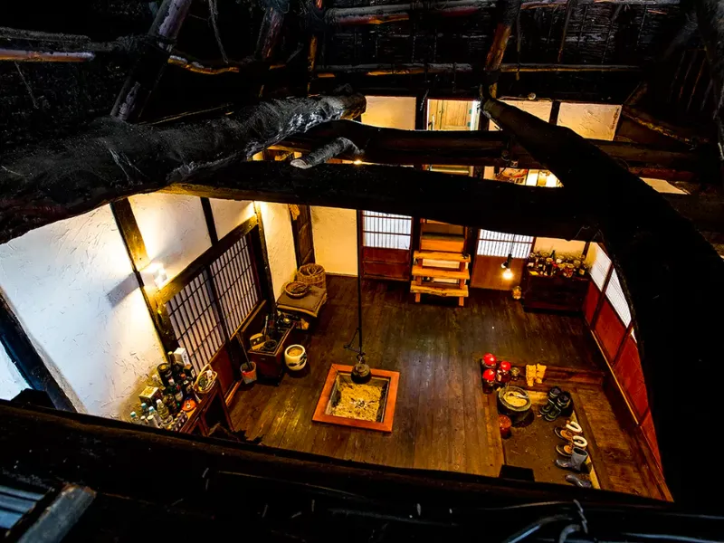 Interior of Kayaya farmhouse inn in Tokamachi, viewed from above with an irori hearth